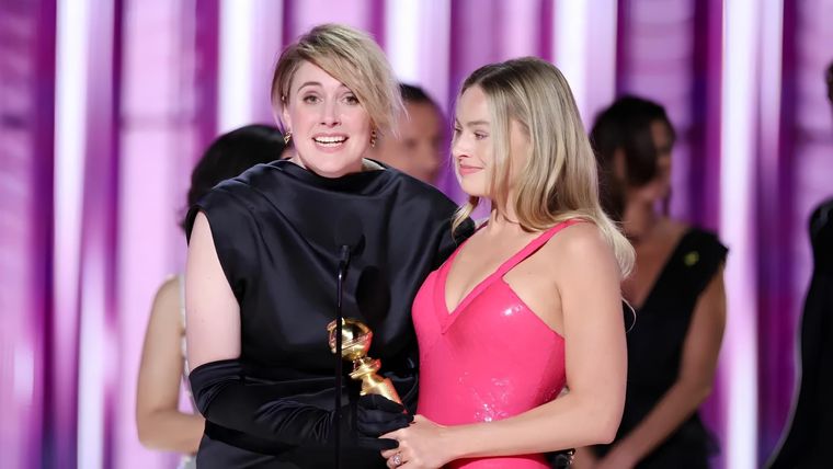 Greta Gerwig y Margot Robbie recibiendo el premio al Logro Cinematográfico y de Taquilla por Barbie.