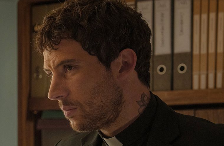 El tatuaje en el cuello del Padre Jud en Knives Out. El tatuaje en el cuello del Padre Jud en Knives Out.