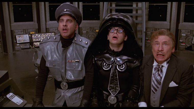 El Colonel Sandurz (George Wayner), Lord Helmet (Rick Moranis) y el Presidente Skroob (Mel Brooks), en Spaceballs. El Colonel Sandurz (George Wayner), Lord Helmet (Rick Moranis) y el Presidente Skroob (Mel Brooks), en Spaceballs.