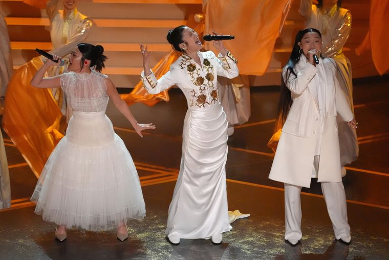 Rei Ami, EJAE y Audrey Nuna sobre el escenario para cantar Golden, en una de la presentaciones en vivo más aplaudidas de los premios Oscar. Rei Ami, EJAE y Audrey Nuna sobre el escenario para cantar Golden, en una de la presentaciones en vivo más aplaudidas de los premios Oscar.